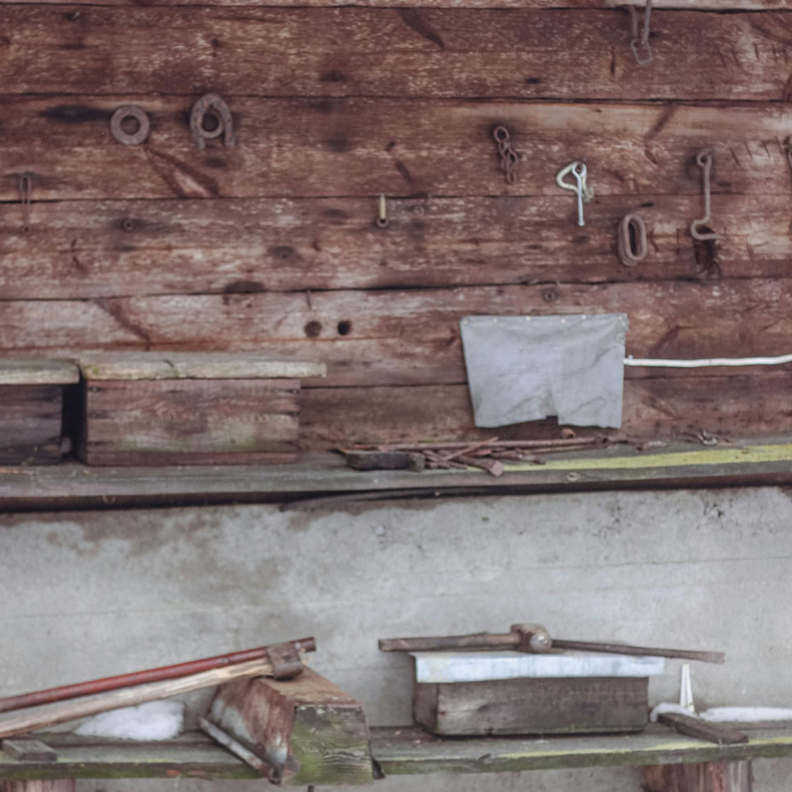 Aged barn wall with tools and shelves in a rustic Polish setting.