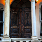 A vintage wooden doorway with arches and columns, exuding historic charm.